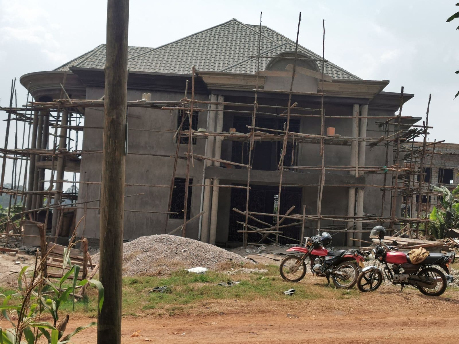Two-storey superstructure under scaffolding with roofing complete